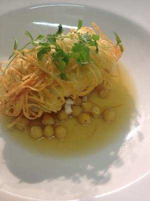 Potato wrapped fillet of Turbot with a stew of chickpeas & roasted squid consomme