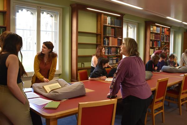 Dr Tuija Ainonen (Parker Library Sub-Librarian) and student Rhiannon Warren discuss a manuscript with students.